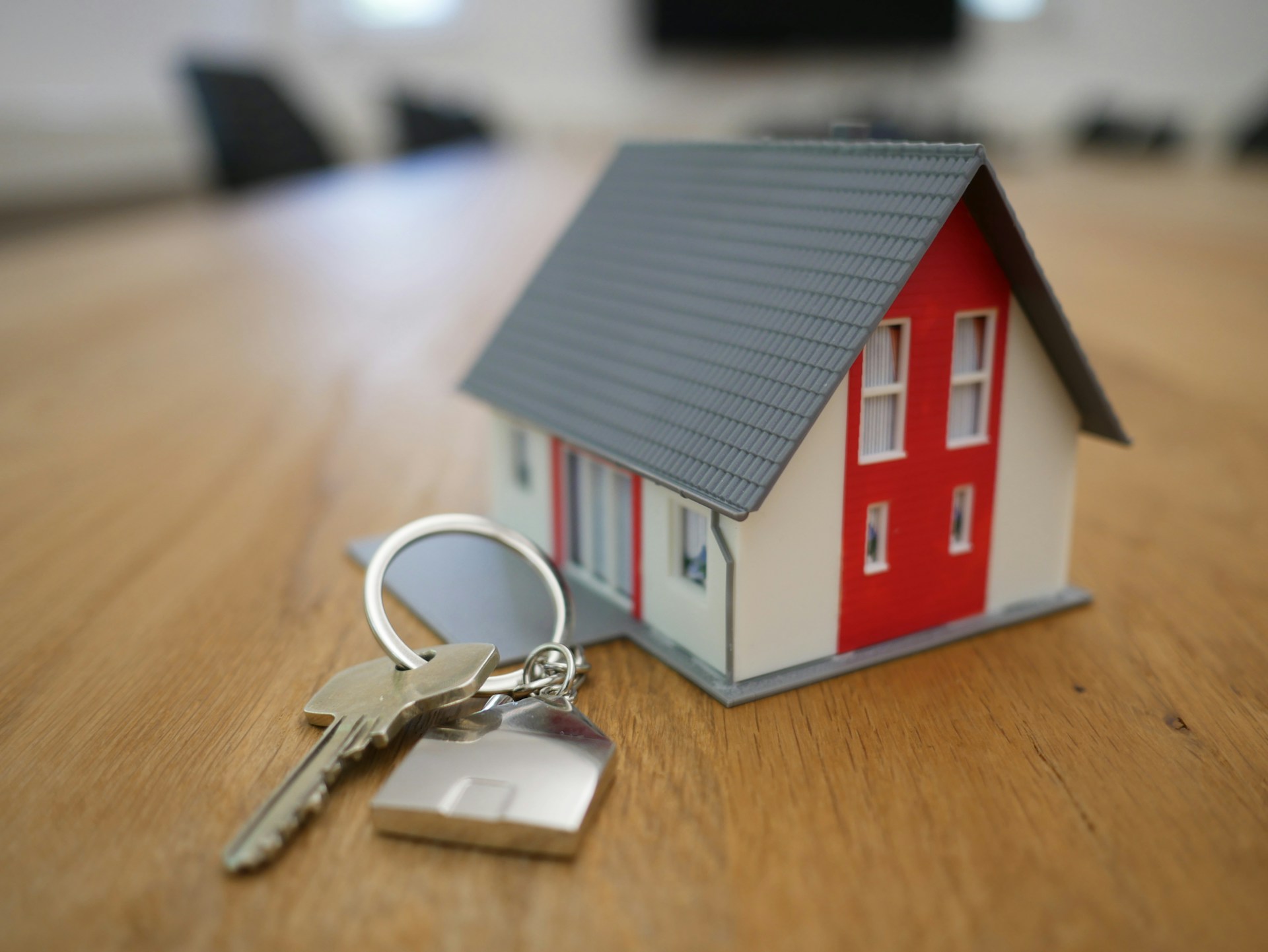 Close up of a toy home with keys sitting next to it