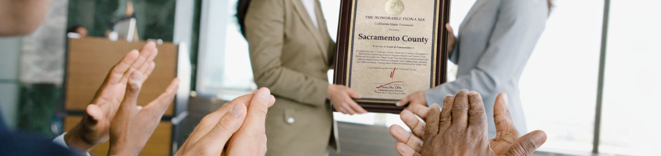 People holding up Sacramento County Award