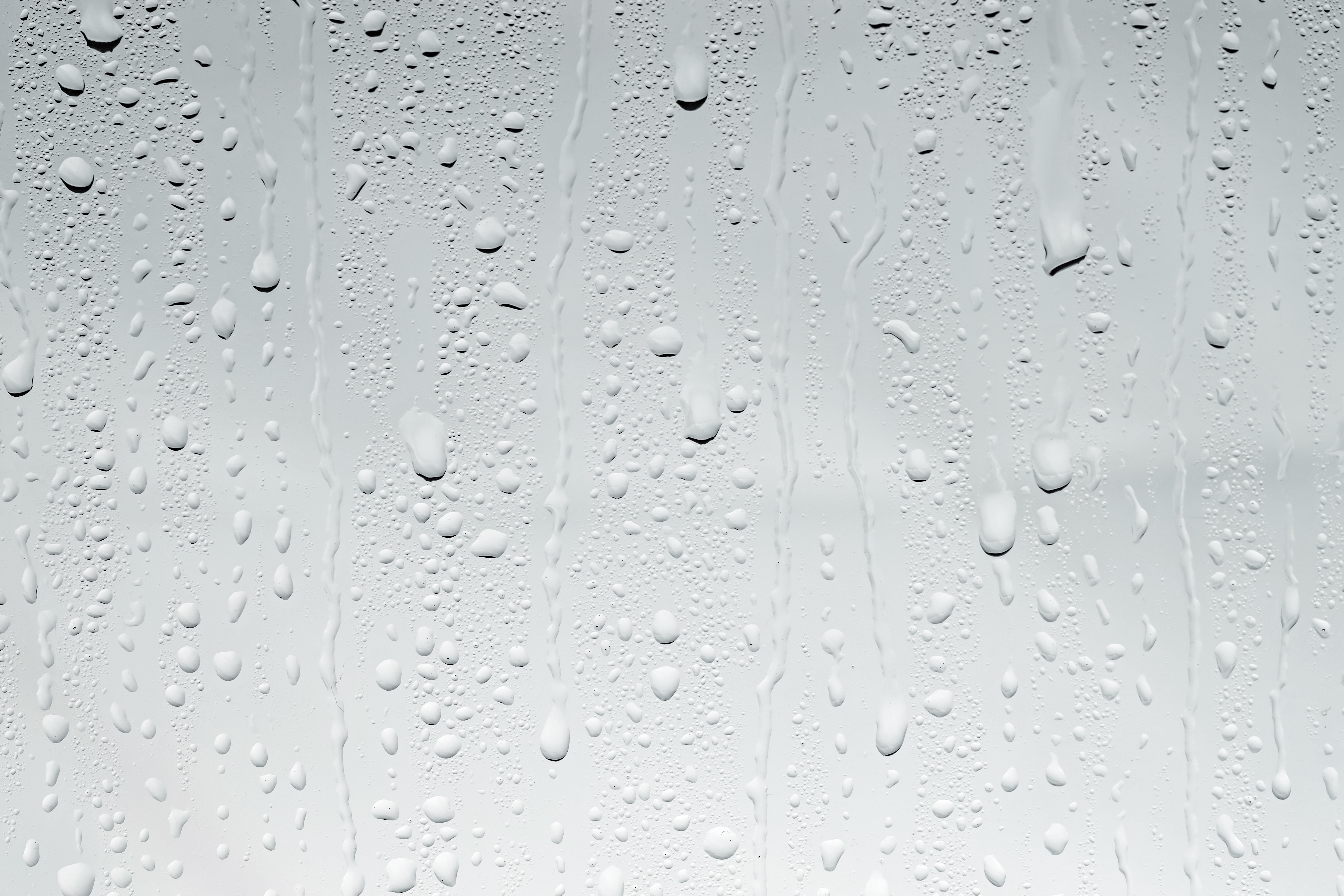 Water drops on light glass surface, top view