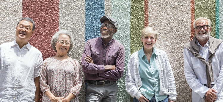 Group of diverse elderly people against a colorful wall