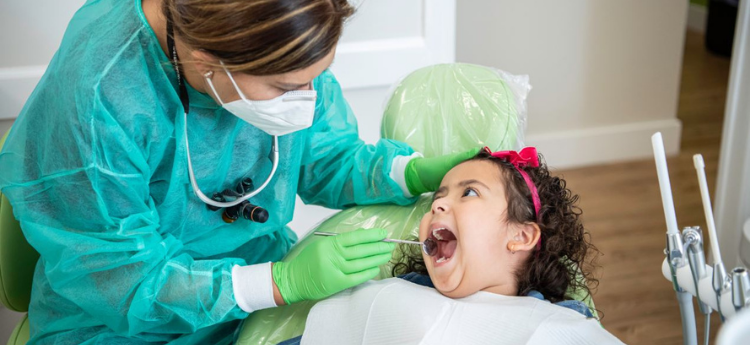 Young female child sitting in a dentists chair 