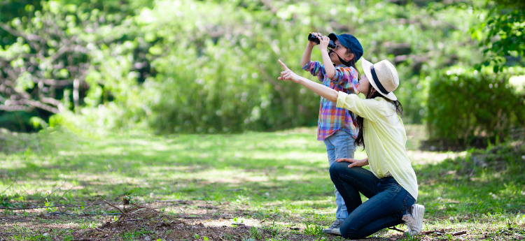 Mother and son birdwatching in a park