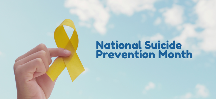 Hand holding a yellow ribbon with a cloudy background "National Suicide Prevention Month