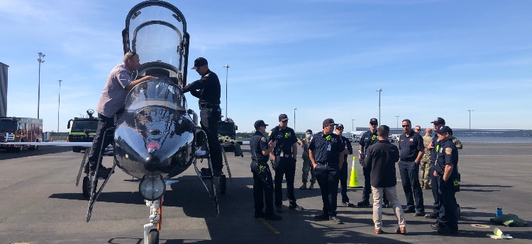 Sacramento International Airport emergency response staff studying a military jet