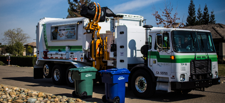 Waste management collection vehicle collecting a cart