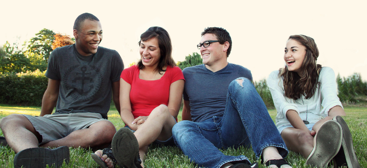 Group of young adults sitting on a lawn