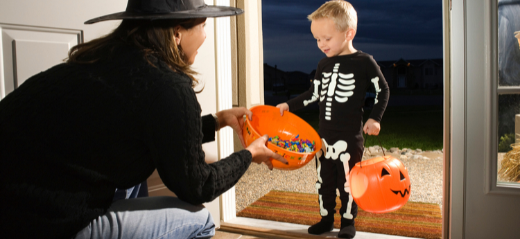 Young child dressed as a skeleton trick-or-treating