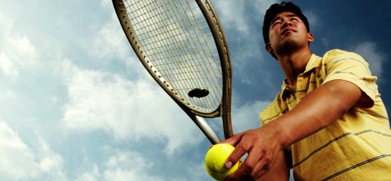 man serving tennis ball