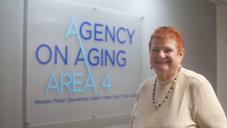 Photo of woman standing next to a sign that says Agency on aging area 4